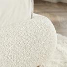 Close-up of a textured white cushion on a chair with a blurred wooden floor background