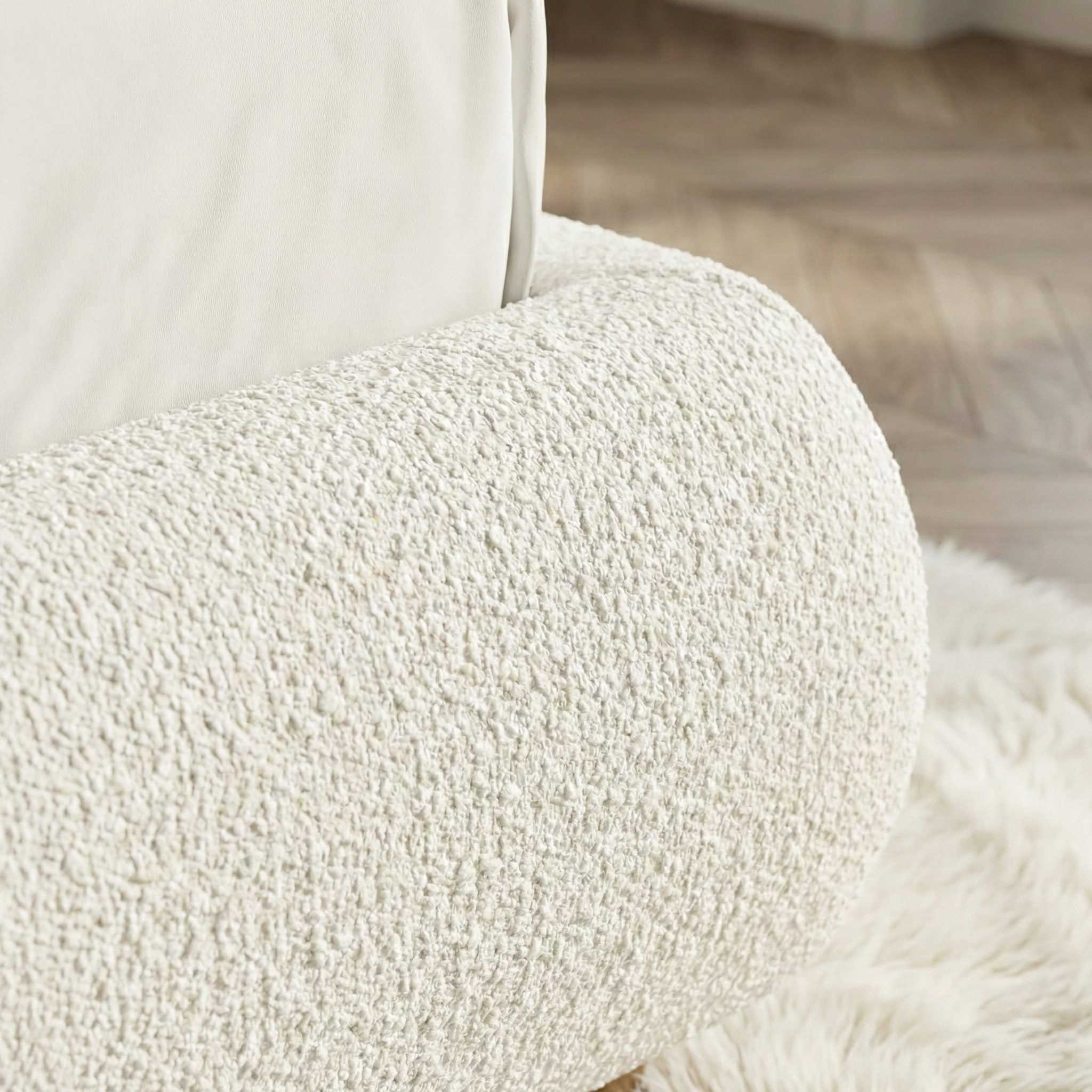 Close-up of a textured white cushion on a chair with a blurred wooden floor background