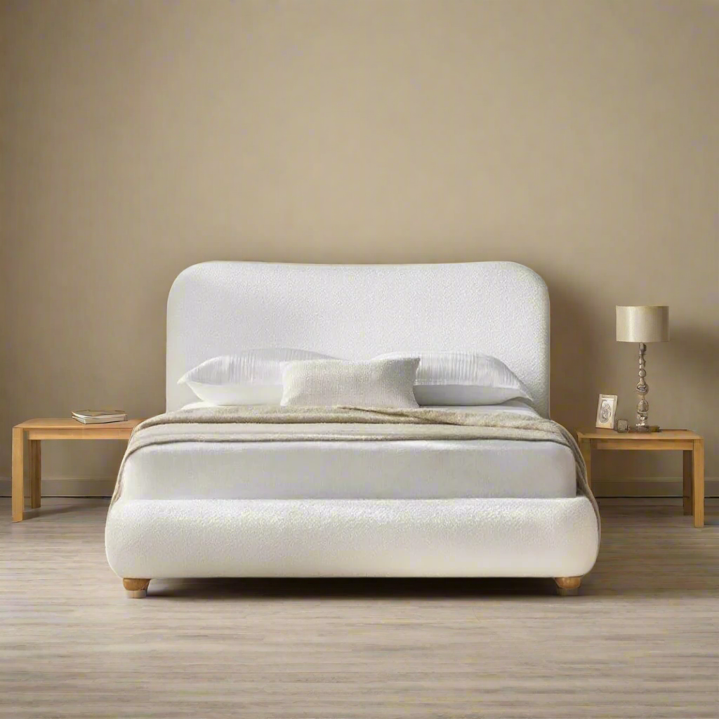 Luma Bouclé Bed with curved headboard and wooden legs styled in a cozy bedroom with matching nightstands and neutral tones