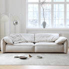 Luxury Elephant Ear Sofa in cream ultra suede placed in a bright living room with large windows and neutral decor