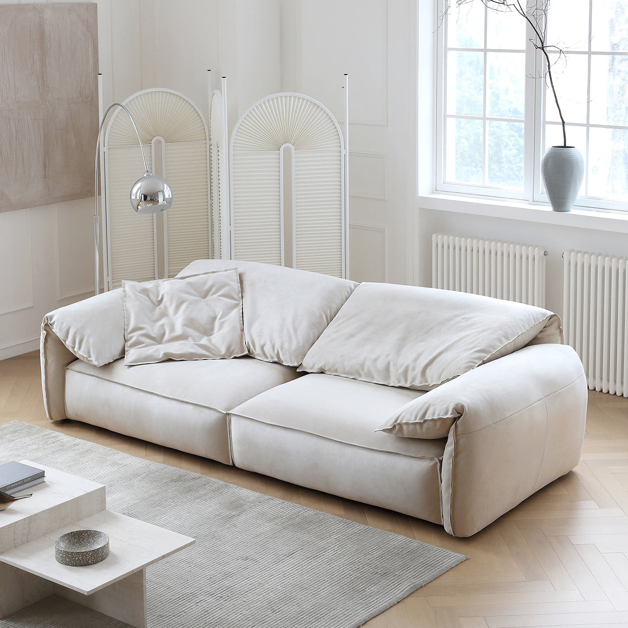 Luxury Elephant Ear Sofa in cream ultra suede with soft slouchy cushions and rounded arms in a bright living room