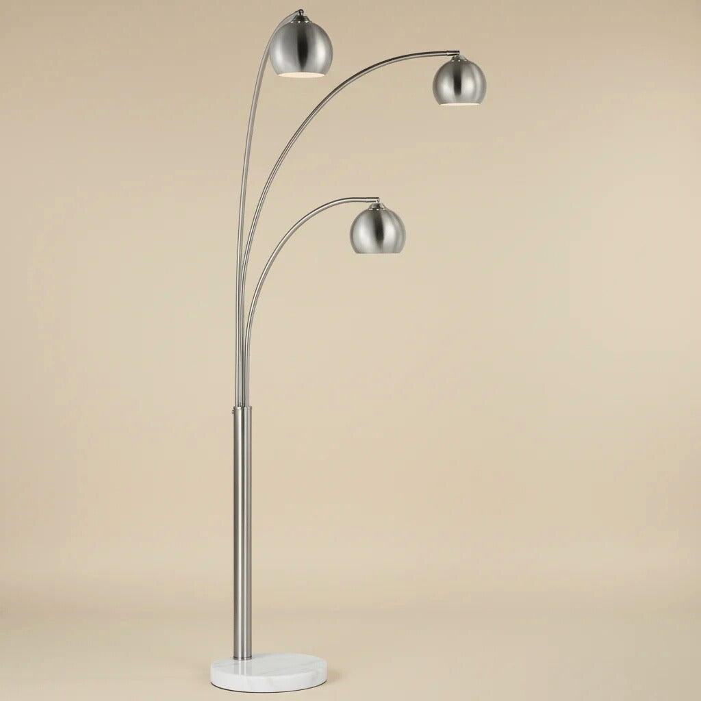 Three-arm floor lamp with silver finish on a beige background