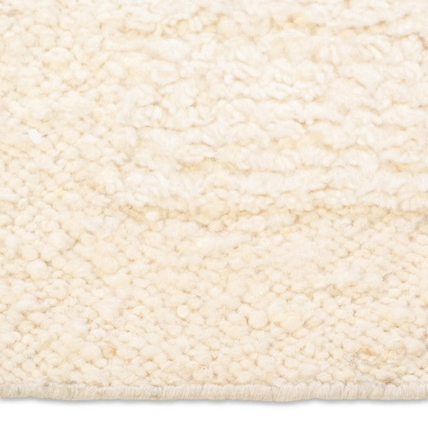 Macro detail of the Maeve hand-woven rug surface highlighting the ultra-textured, chunky nubby wool pile in warm cream.