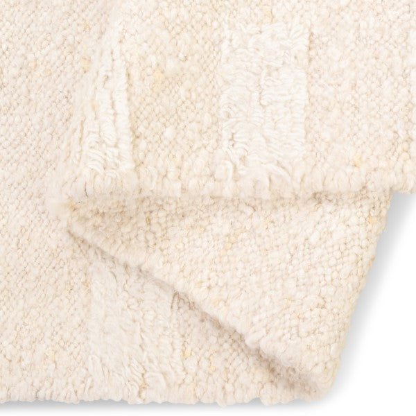 Folded view of the Maeve wool rug showcasing its thick chunky pile and authentic hand-woven backing without a canvas layer.