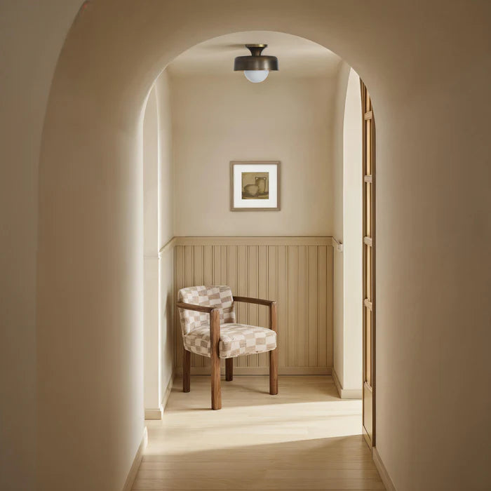 The Margot vessel wall art styled in a serene, neutral hallway with an arched doorway and a checkered accent chair.