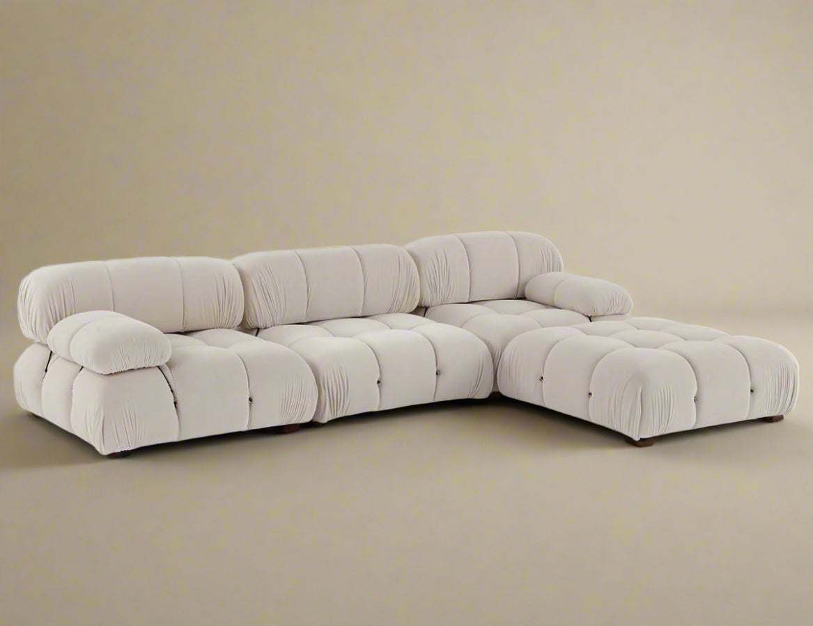 Mario Bellini Sofa in white bouclé fabric arranged in an L-shaped sectional with deep tufting and plush cushions on beige background