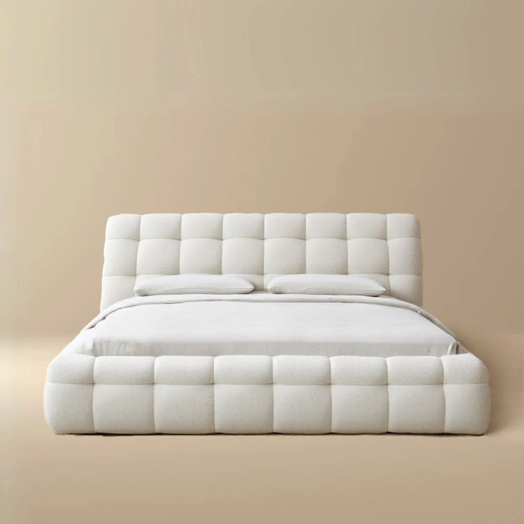 Front view of the Marshmallow Puff bed featuring a deep biscuit-tufted headboard and chunky upholstered rails in cream boucle fabric.