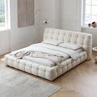 Marshmallow Puff Bed in soft white boucle fabric with tufted frame and pillows styled in bright modern bedroom with wooden floors