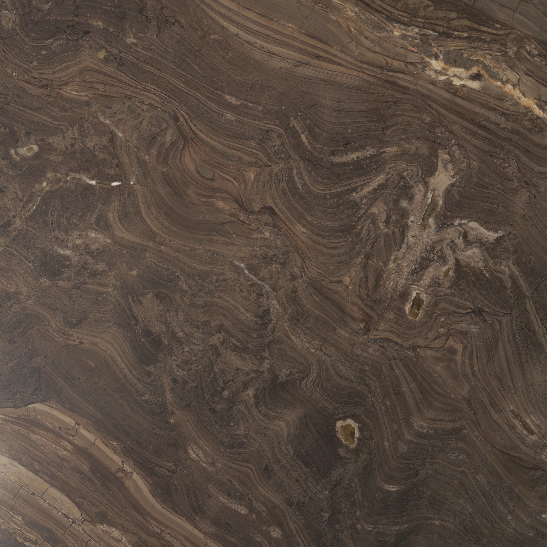 Macro close-up of the Mateo dining table's marble top showcasing the rich, intricate white and tan veining against a dark brown stone.