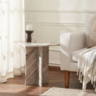 Mesa marble end table styled next to a cream armchair in a sunlit living room, highlighting the warm tones of the natural stone.