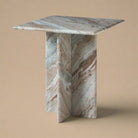 Mesa side table featuring a square top and geometric cross base in dramatic multicolor marble with pink and grey veining.