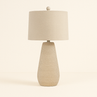 Mesa Glow Table Lamp with textured beige ceramic base and matching fabric shade in soft neutral studio setting