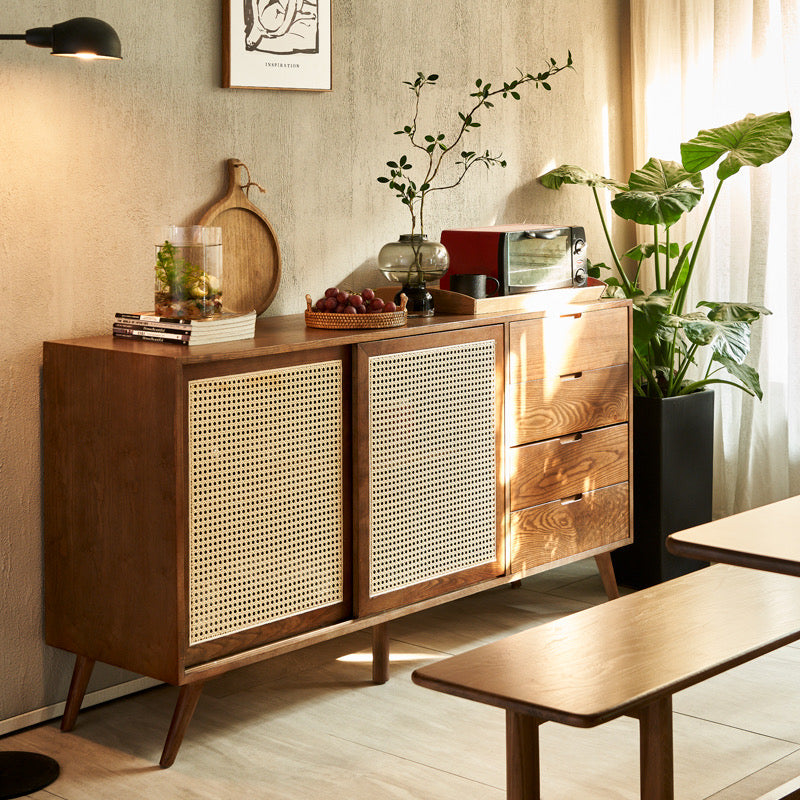 Mid-Century Rattan Craft Sideboard with sliding cane doors and wood drawers styled in a cozy dining space.