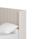 Close-up side profile of the Mila upholstered bed highlighting its modern, clean-lined wingback headboard design and textured cream fabric.