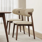 Two Modern Leather Ash Wood Dining Side Chairs shown in a bright dining room, featuring curved upholstery and solid ash wood legs