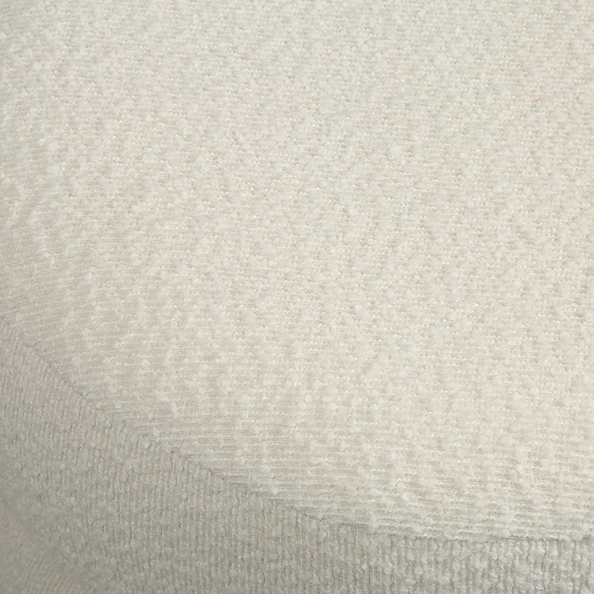 Macro close-up of the soft, nubby white bouclé fabric texture on the top of the Moita round stool.