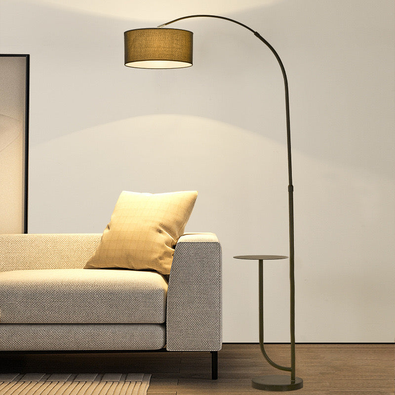 Noir Tray Curve Lamp positioned beside a beige sofa, featuring a built-in tray and warm ambient lighting in a modern living room