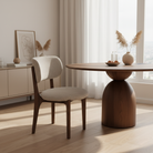 Nolan Linen Ash Wood Dining Chair beside a round wood table in a bright modern dining room with neutral decor