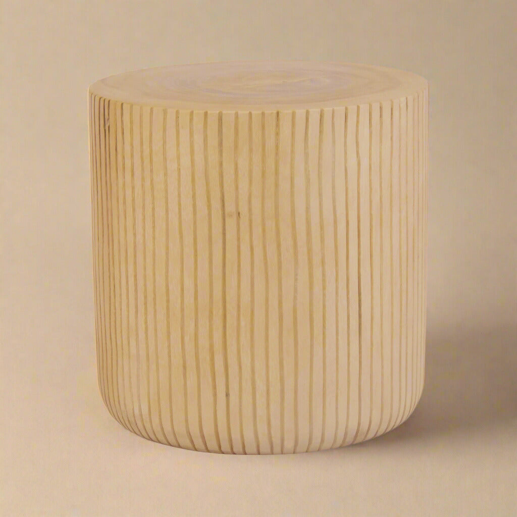 Oaklyn sculpted wood side table featuring a cylindrical drum shape with vertical fluted texture and natural light wood finish.