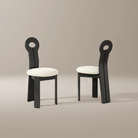 Obsidian Loop Dining Chair set with sculpted black looped backrests and rounded bouclé seats in a neutral studio setting