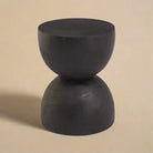 Onda accent table featuring a sculptural hourglass silhouette in matte black solid wood.