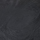 Macro detail of the Ryn side table showing the rich wood grain texture visible through the matte black finish.