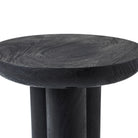 Detail shot of the Ryn black wood side table, showing the smooth rounded edge of the thick top surface.