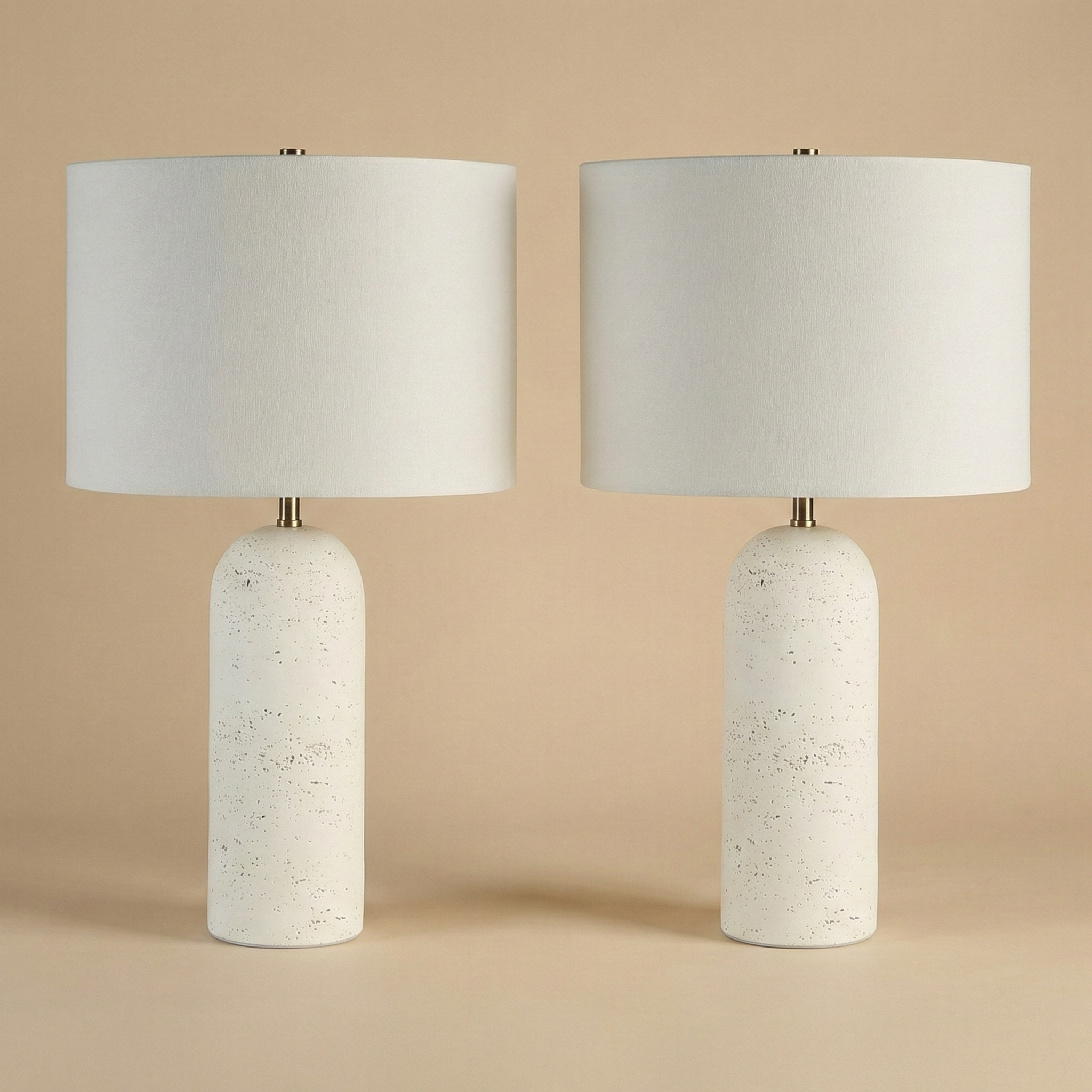 Two table lamps with white textured bases and white lampshades on a beige background