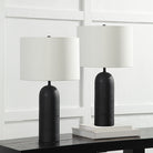 Pair of black Sienna Sculpted Table Lamps with white shades styled on dark console table against white panel wall