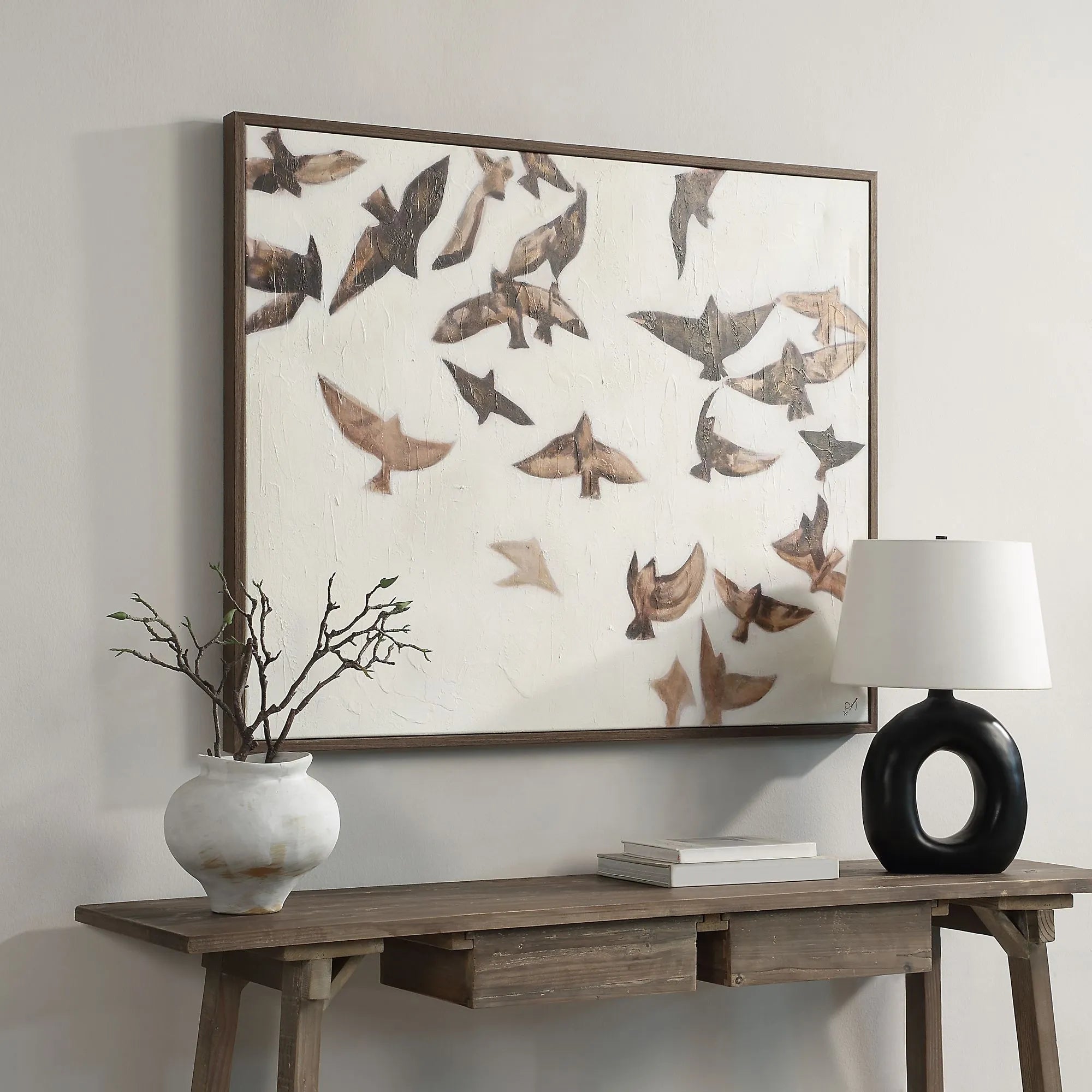 Silent Flight bird painting hanging above a rustic wooden console table with a modern black circular lamp.