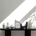 Solana Ceramic Vase styled on black shelf with modern sculptural vases under natural light