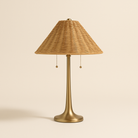 Solara Rattan Glow Table Lamp with brass base and woven rattan shade on beige background
