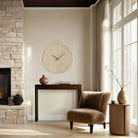 Solea Travertine Wall Clock styled in a cozy living room with brown accent chair and console table
