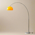 Arc floor lamp with a yellow shade on a beige studio background