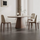 Side view of Sorella pedestal dining table with sintered stone top and solid wood base styled with cream dining chairs