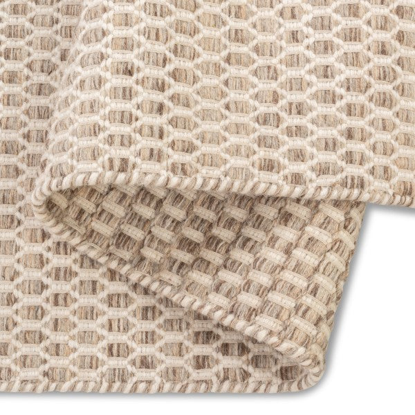 Folded corner of the husk Theo hand-woven rug revealing the consistent honeycomb weave pattern on both sides.