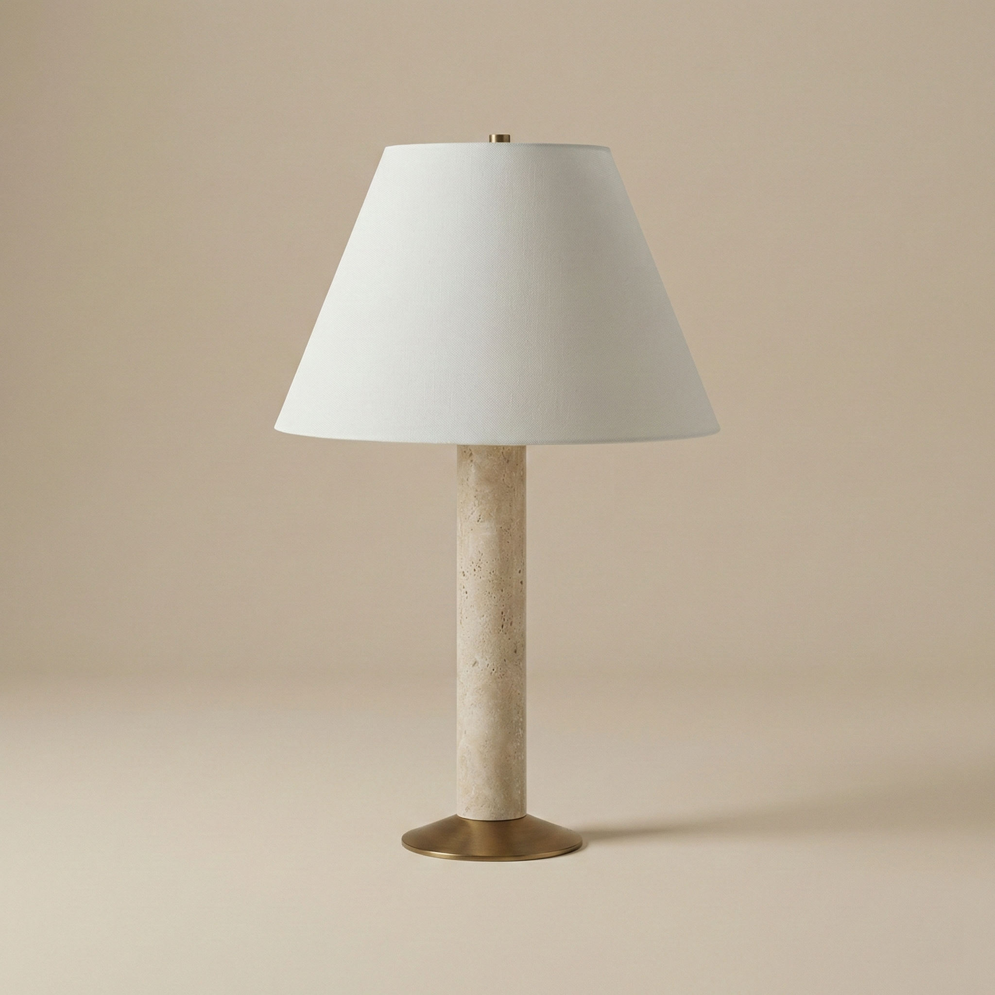 Full view of the unlit Tivoli travertine table lamp featuring a cylindrical stone body, brass base, and white tapered shade.