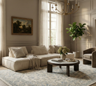 Luxurious living room with beige sofa, round coffee table, and decorative elements.