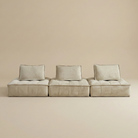 Beige modular sofa with three cushions on a beige background