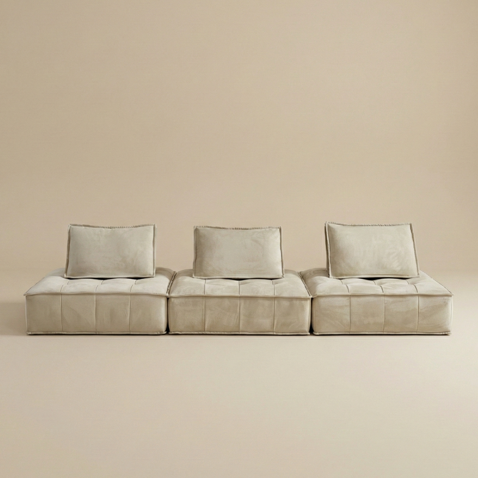 Beige modular sofa with three cushions on a beige background