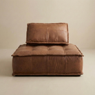Brown leather sofa with a pillow on a beige background