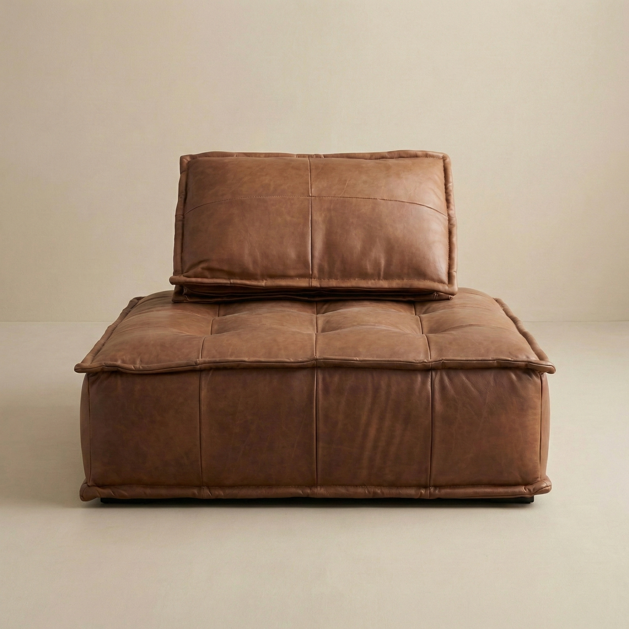Brown leather sofa with a pillow on a beige background