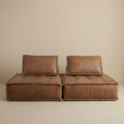 Brown leather sofa against a beige wall