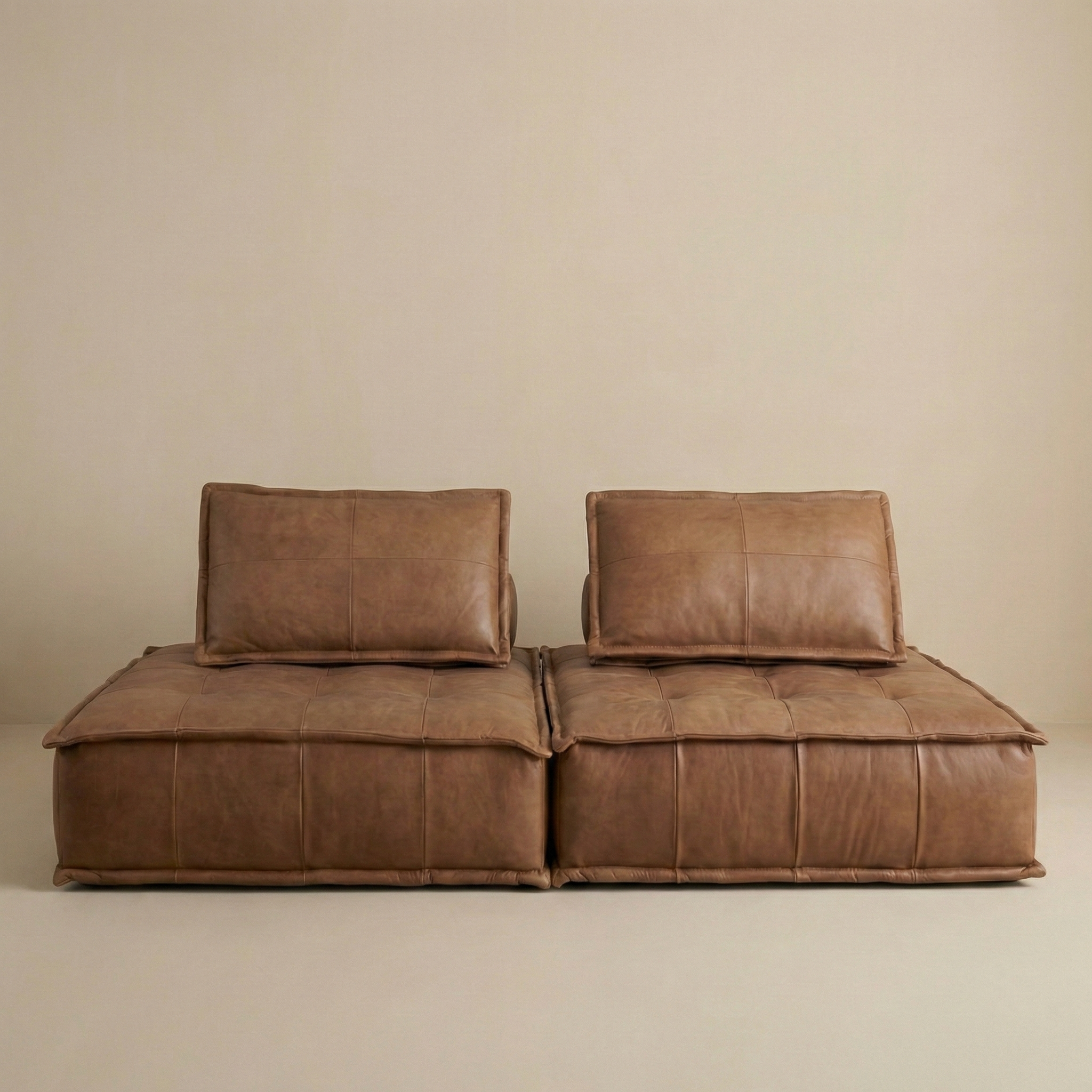 Brown leather sofa against a beige wall