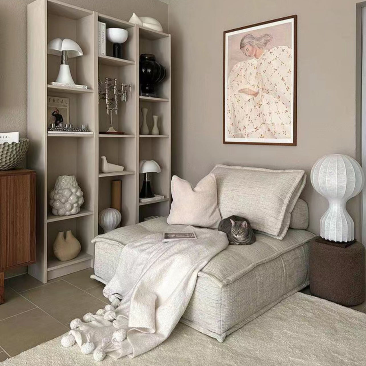 Tofu Modular Sofa in soft linen fabric styled in neutral reading corner with bookshelf, warm lighting, and cozy decor