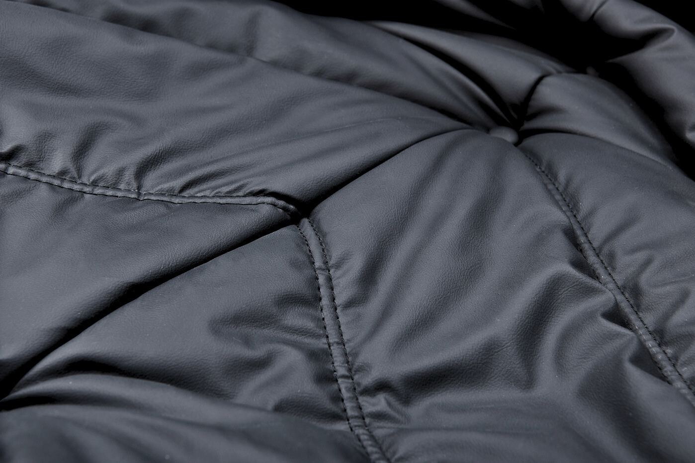 Macro texture shot of the TOGO Lounger upholstery showing the durable stitching and button tufting detail.