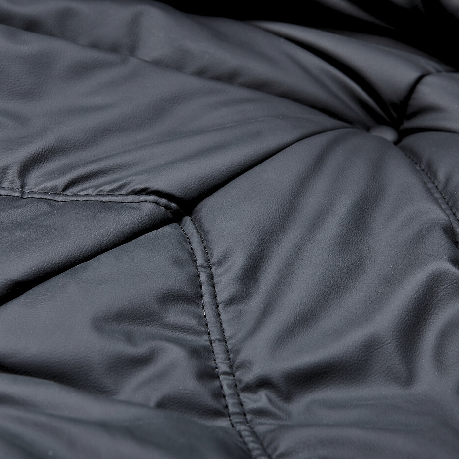 Macro texture shot of the TOGO Lounger upholstery showing the durable stitching and button tufting detail.