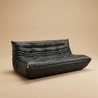 Black leather sofa on a beige background