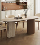 Side view of travertine sintered stone dining table with wood base and cream chairs in elegant kitchen interior