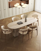 Top view of travertine sintered stone dining table with wood base and six cream chairs in modern kitchen interior